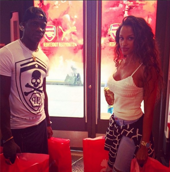 Balotelli and girlfriend Fanny Neguesha, standing in front of Arsenal logo