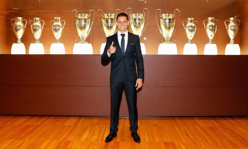 Javier Hernandez Chicharito standing in front of Real Madrid's 10 UEFA Champions League trophies