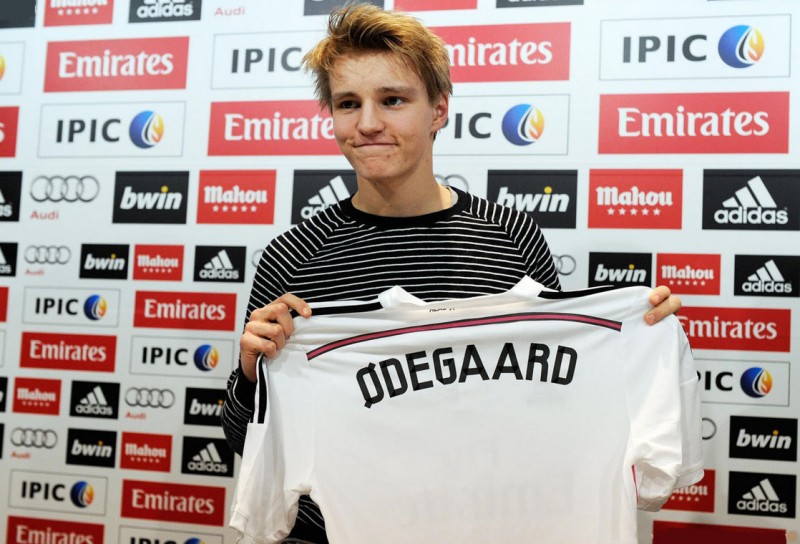 Martin Odegaard holding his new Real Madrid shirt