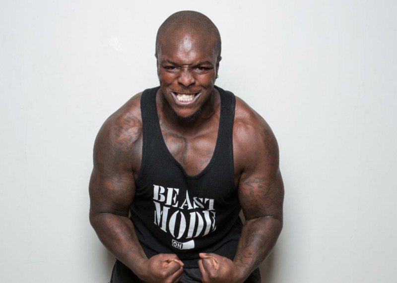 Adebayo Akinfenwa showing off his muscles and strength