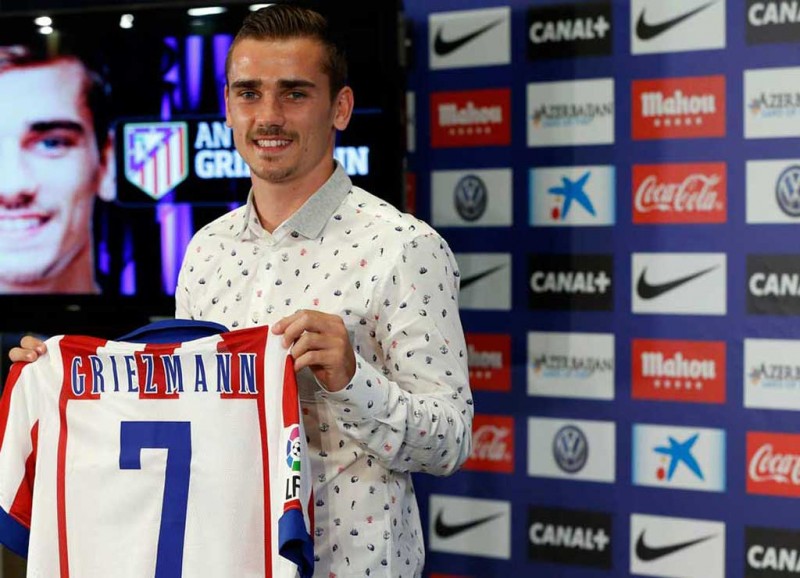 Antoine Griezmann holding his new Atletico Madrid jersey