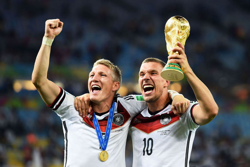 Bastian Schweinsteiger and Podolski, holding the World Cup trophy