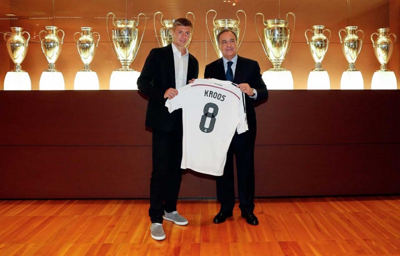 Toni Kroos holding his new Real Madrid jersey number 8, on his presentation