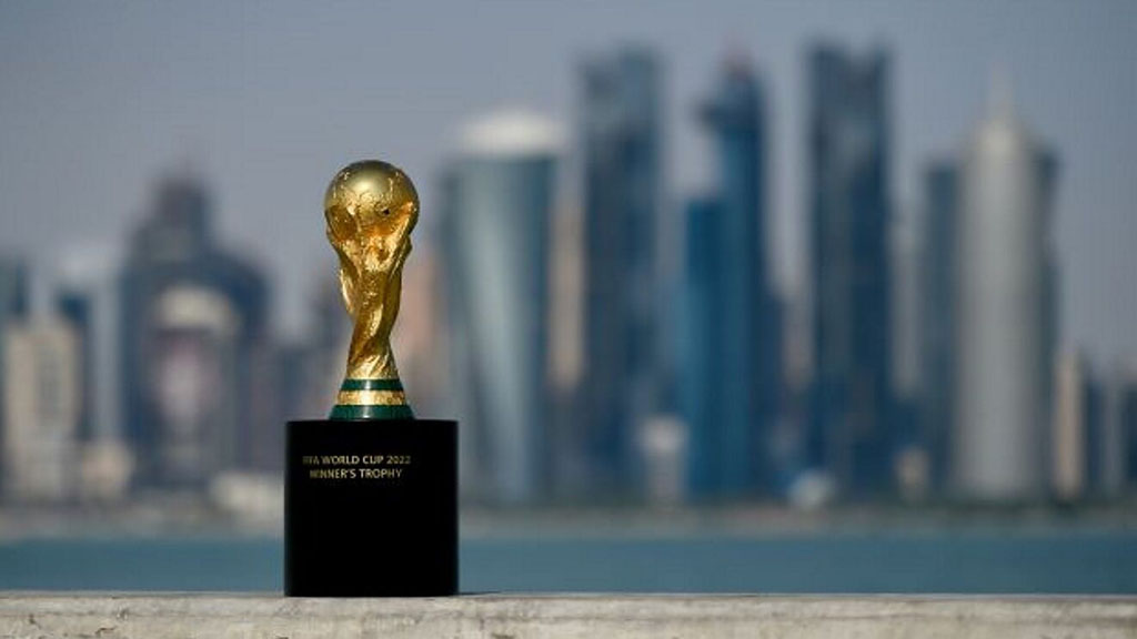 The FIFA World Cup trophy with Qatar behind